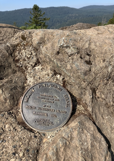 Plaque for Mount Finlayson Trail on a rock.