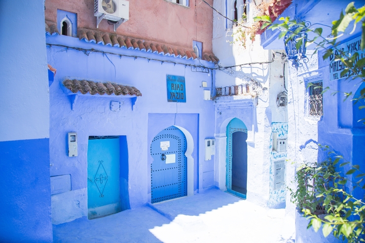 Street with blue-painted buildings and Moroccan architecture.