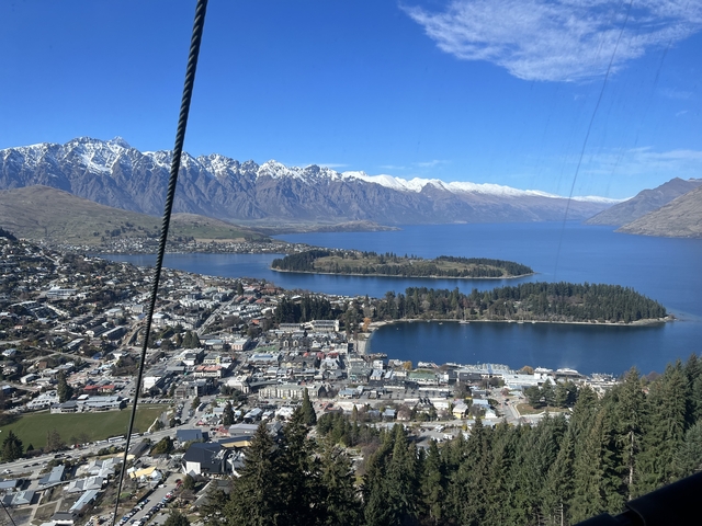 Aerial view of a cityscape with a lake surrounded by mountains.