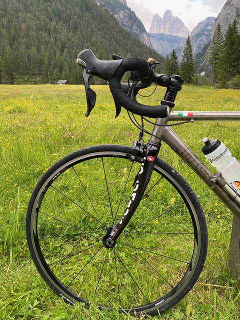       Close-up of a bicycle wheel in a field.
  