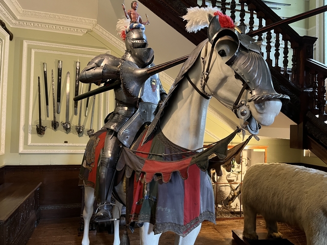 Medieval knight armor on a horse display indoors.