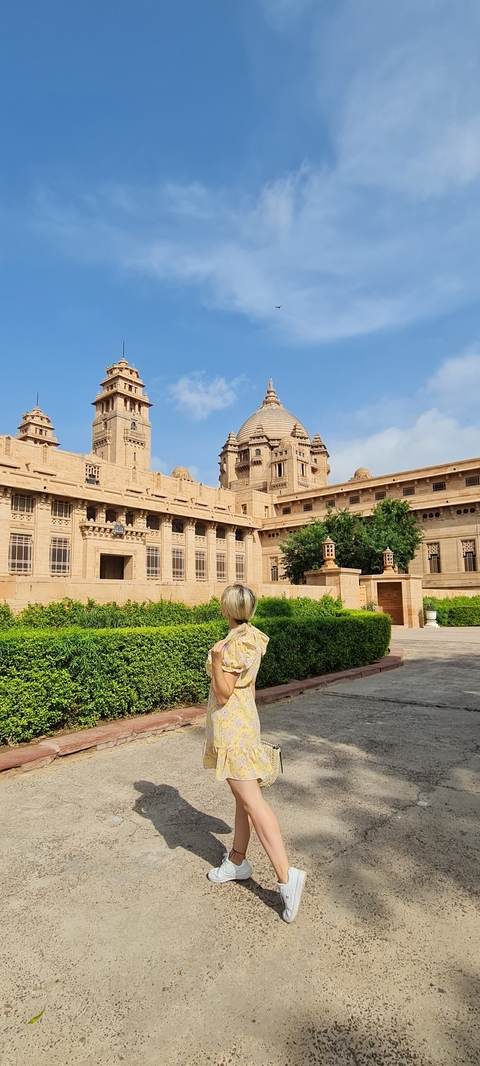       A person looking at a large, ornate sandstone palace.
  