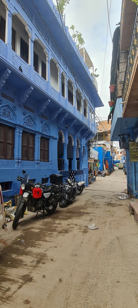       Narrow alleyway with colorful blue walls and intricate architecture.
  