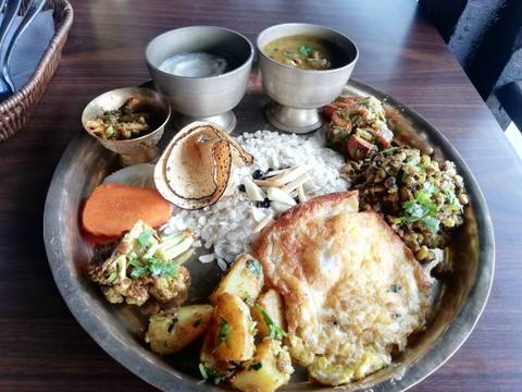      Traditional Nepalese meal served on a brass plate.
  