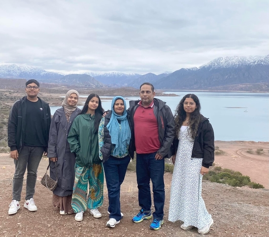 A family posing with mountains in the background.