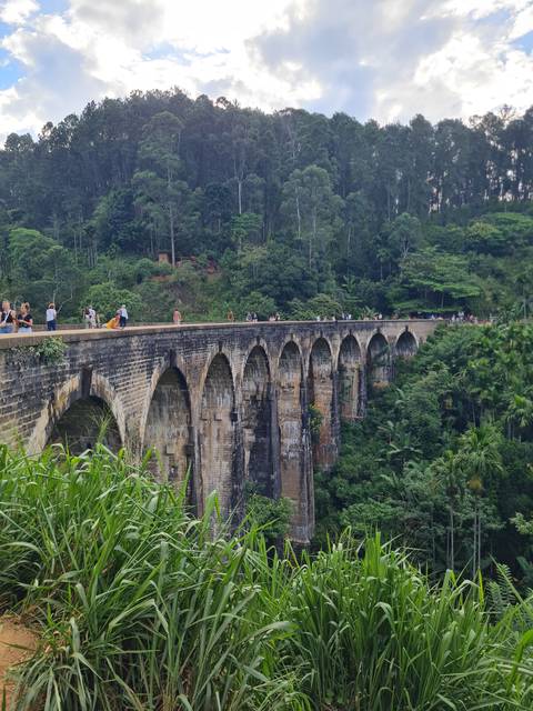 Nine Arch Bridge in a lush green landscape.