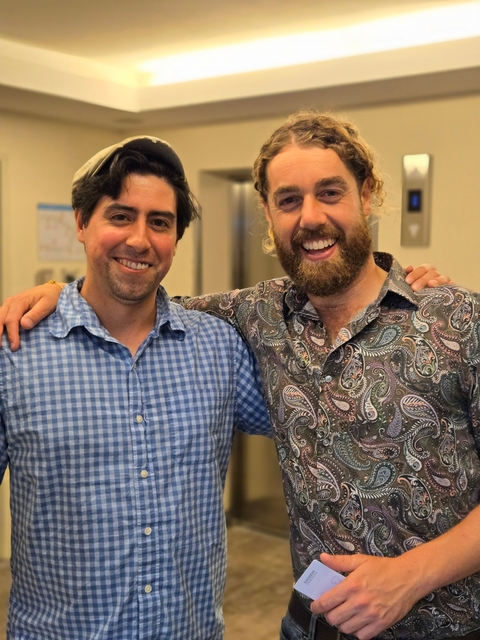 Two people indoors, smiling at the camera.