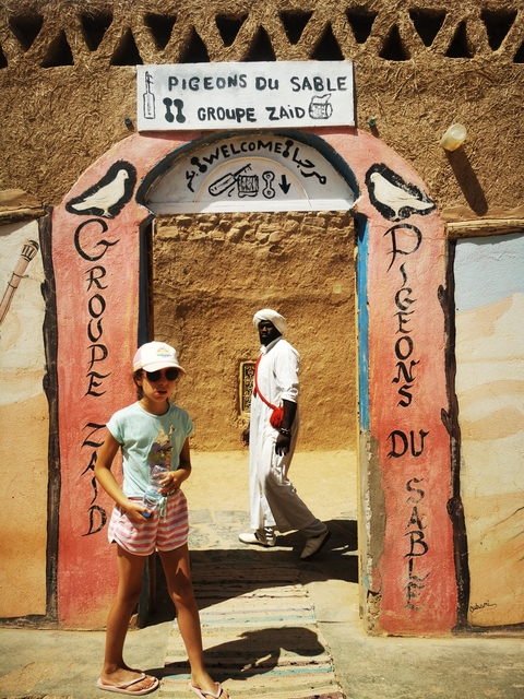       Man and child outside a traditional building with ornamental entrance
  