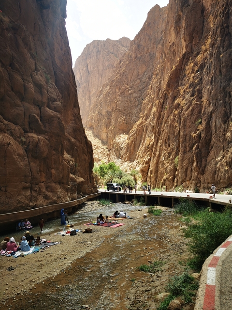       People enjoying a stream within a rocky gorge
  