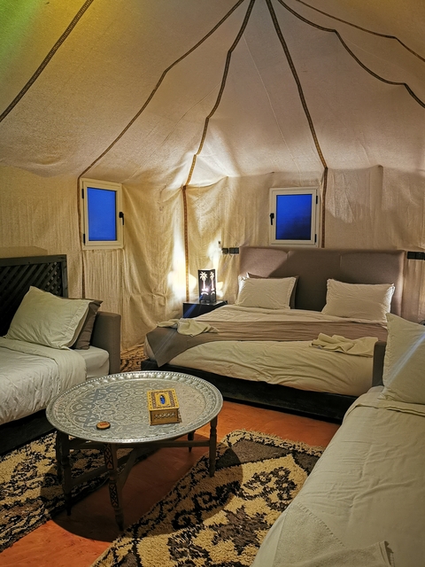       Elegant interior of a tented accommodation with a bed
  