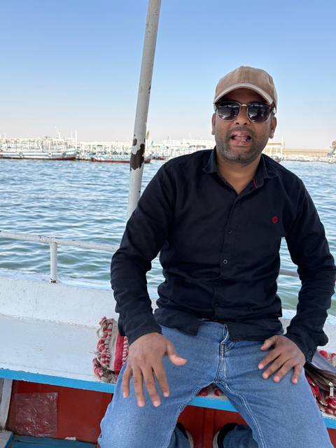 A man in sunglasses sitting on a boat.
