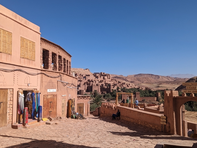       Traditional Moroccan architecture with people walking.
  