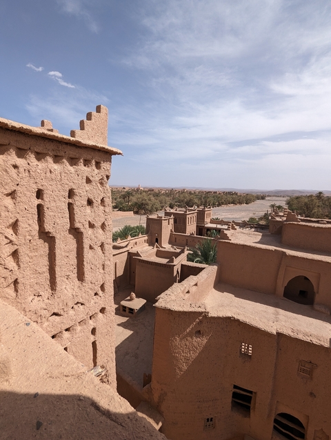       Traditional mudbrick structures with an expansive desert landscape in the background.
  