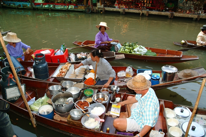 Floating market with people interacting and selling goods on boats.