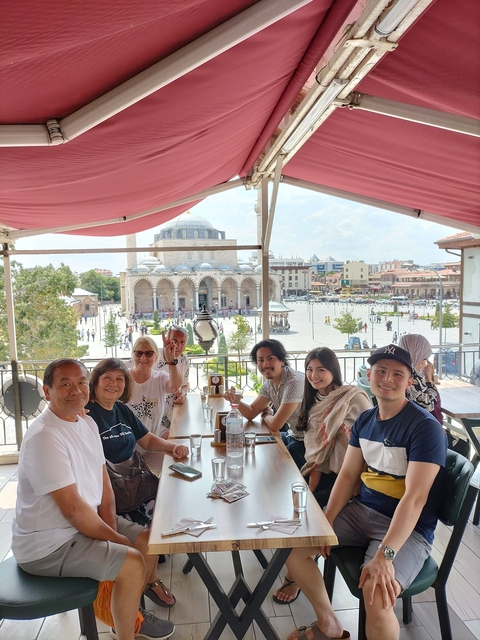 Group dining at a terrace overlooking a historic mosque.