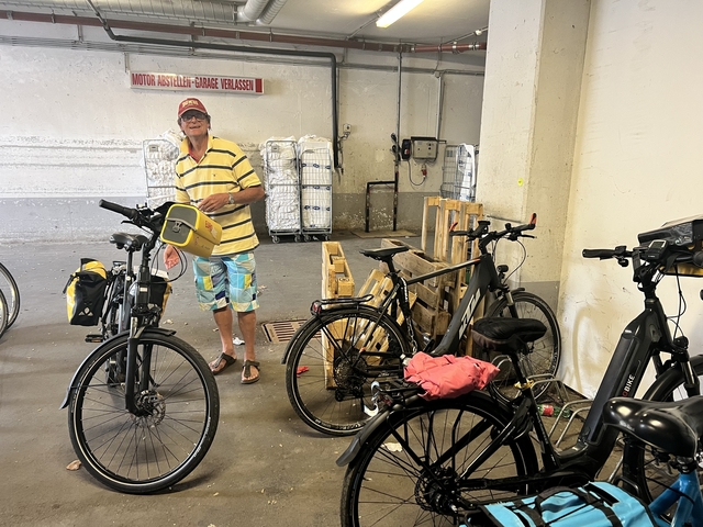 Person standing with bicycles in a storage area