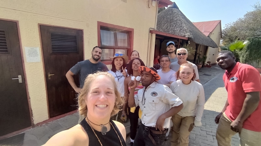       Group of people posing at a guesthouse.
  