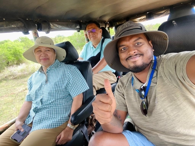 Group inside a safari jeep with thumbs up.