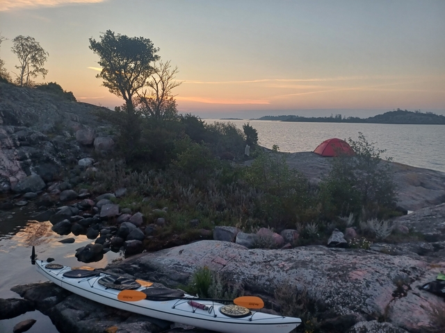       Coastal landscape with a red tent.
  