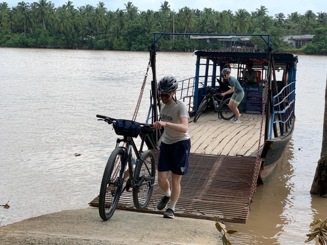 Cyclists disembarking from a boat onto a dock.