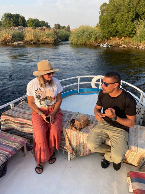       People sitting on a boat on a river.
  