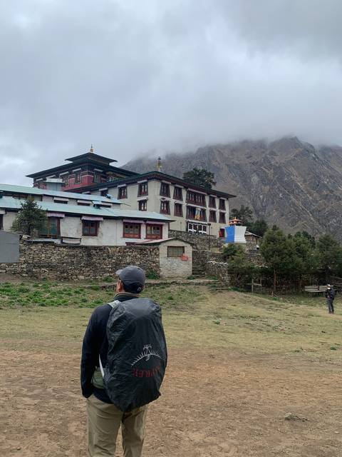       A person walking toward a monastery.
  