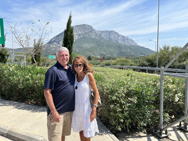       A couple posing with a mountainous landscape in the background.
  