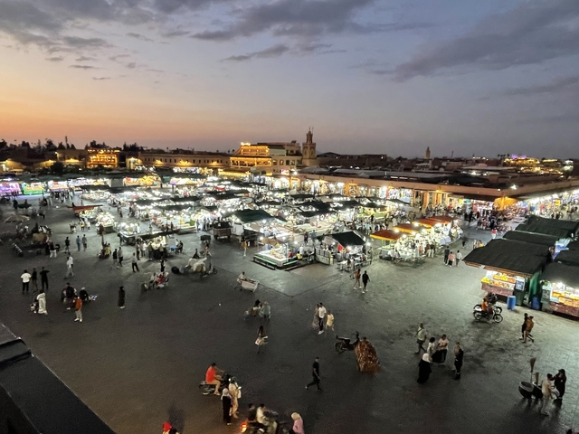 Market square bustling with activity and vendors at sunset.