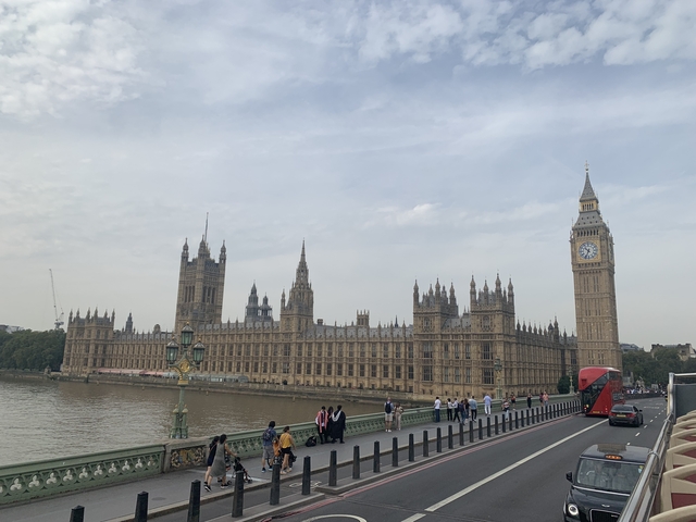 People walking near the Houses of Parliament and Elizabeth Tower in London.