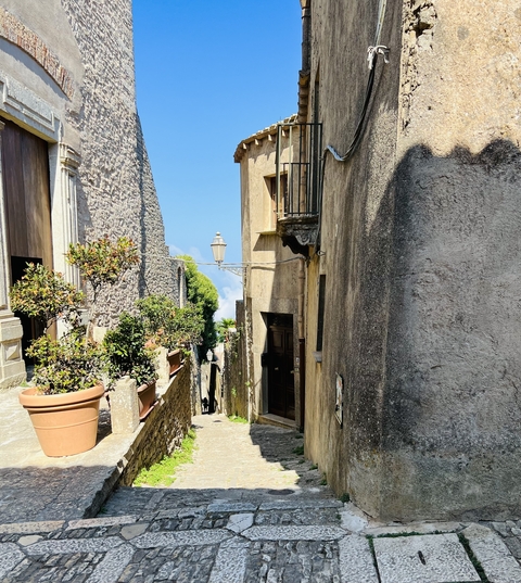       Narrow alley in a historic town with stone walls.
  