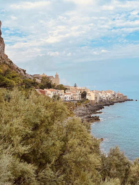 Historic coastal town with buildings, cliffs, and ocean view.