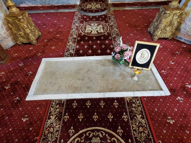       Decorated grave with flowers and a portrait.
  