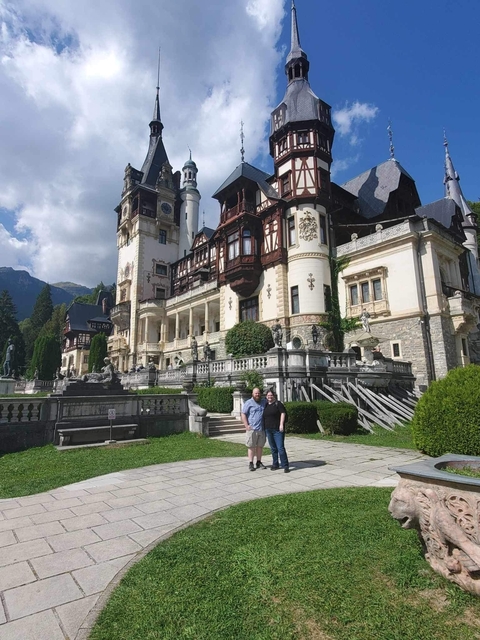       People standing before an ornate historic building.
  