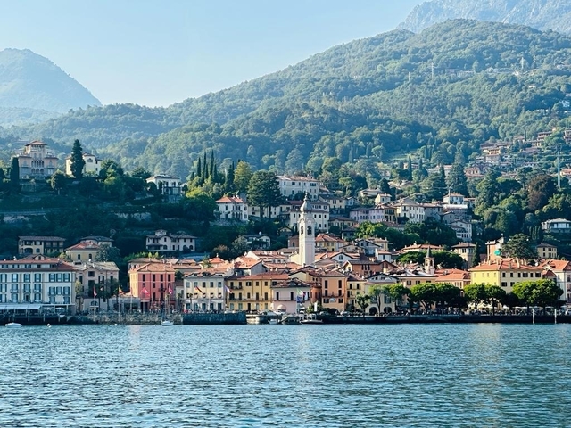 Colorful town on hills seen from across a lake.