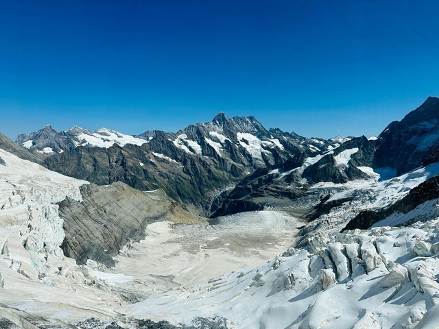 Snow-covered mountains with a glacier in the foreground.