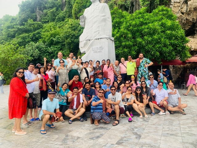 Tourists posing in front of a large statue