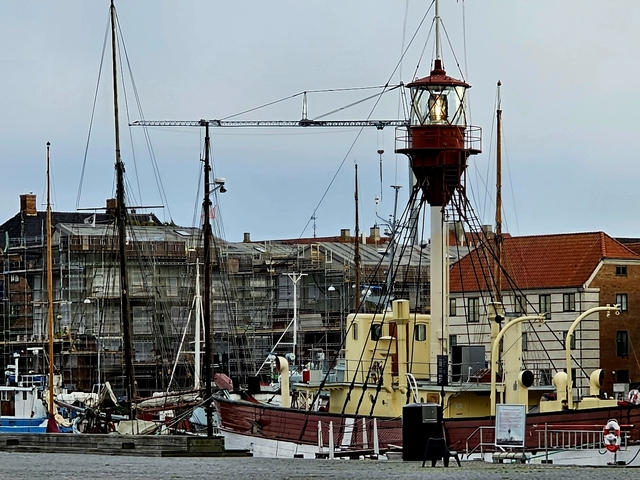 Harbor scene with boats and a lighthouse structure.