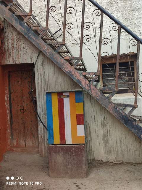       Exterior stairway with rustic decorated walls.
  
