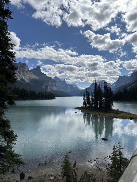       Lakeside with mountains under a partly cloudy sky.
  
