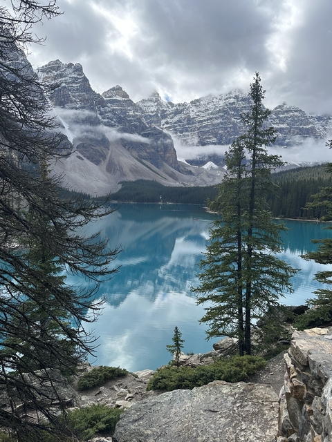 Vibrant blue lake with mountains and trees.