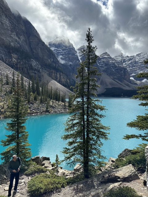 Turquoise lake with surrounding mountains and forests.
