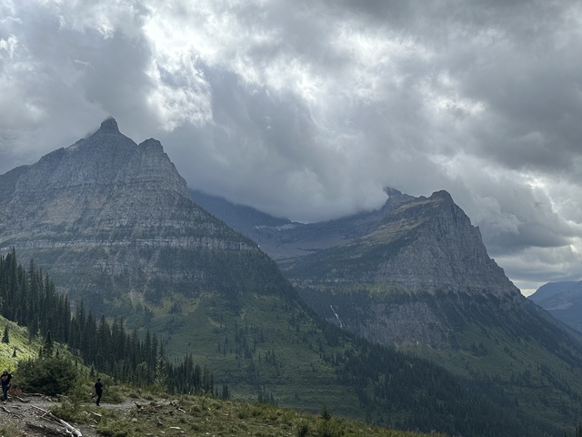       Cloudy mountain landscape with dense forests.
  