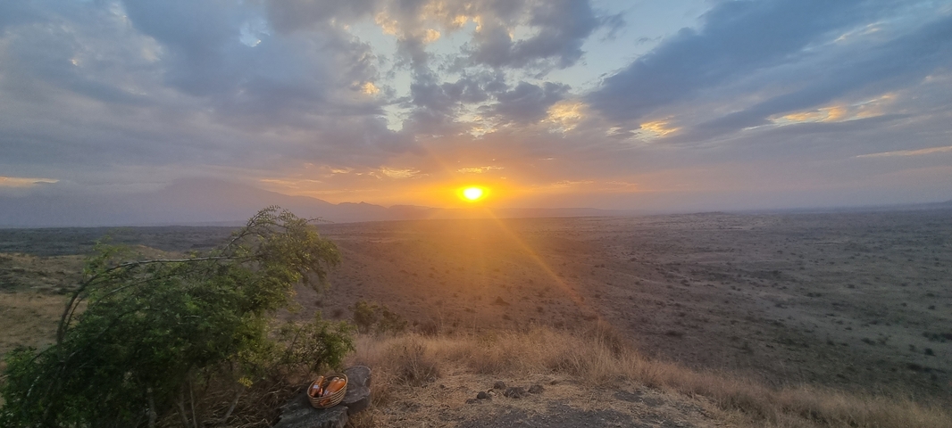 Sunset view over a vast landscape with distant mountains.