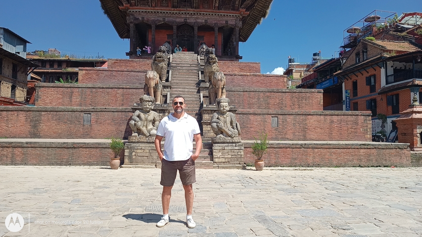       Person standing in front of an ancient structure with stone steps.
  