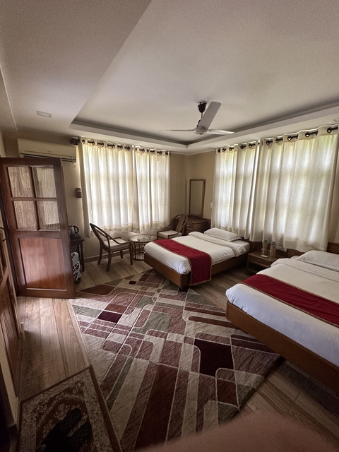       A cozy well-lit hotel room with twin beds.
  