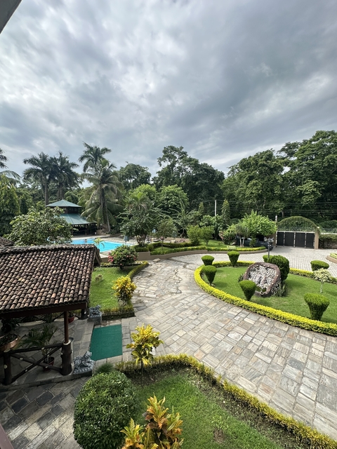       A resort with a pool and lush green surroundings.
  