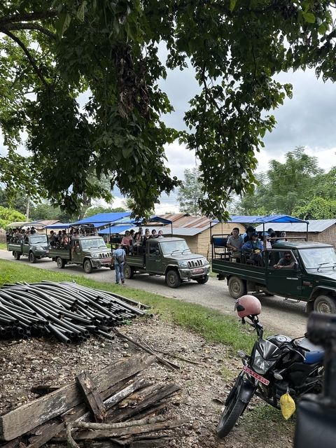       A row of open-top safari vehicles with people.
  
