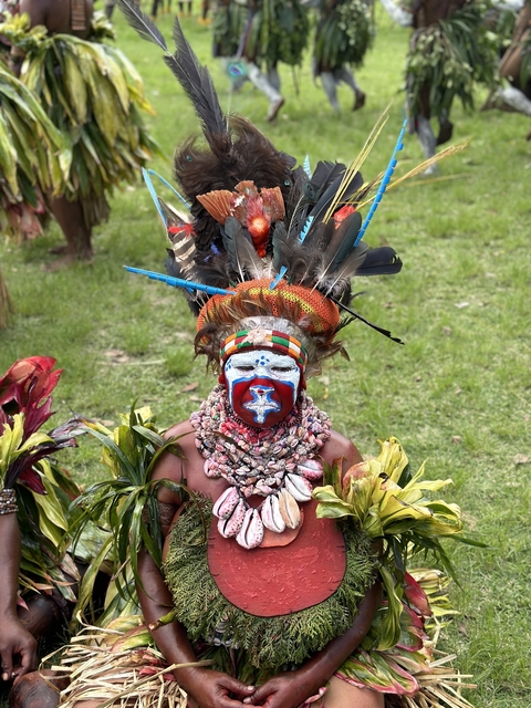 A person in intricate traditional attire with a face mask.