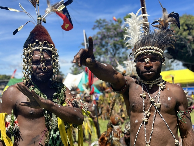 Two men in traditional attire participating in a cultural event.