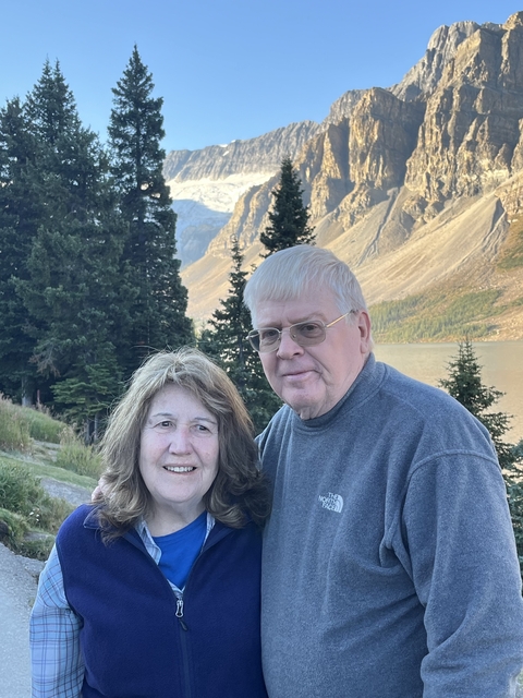       A couple posing in a mountainous landscape.
  
